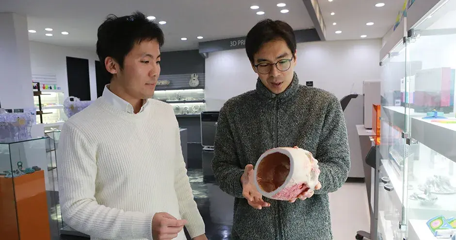 2 名同事正看着 3D 打印