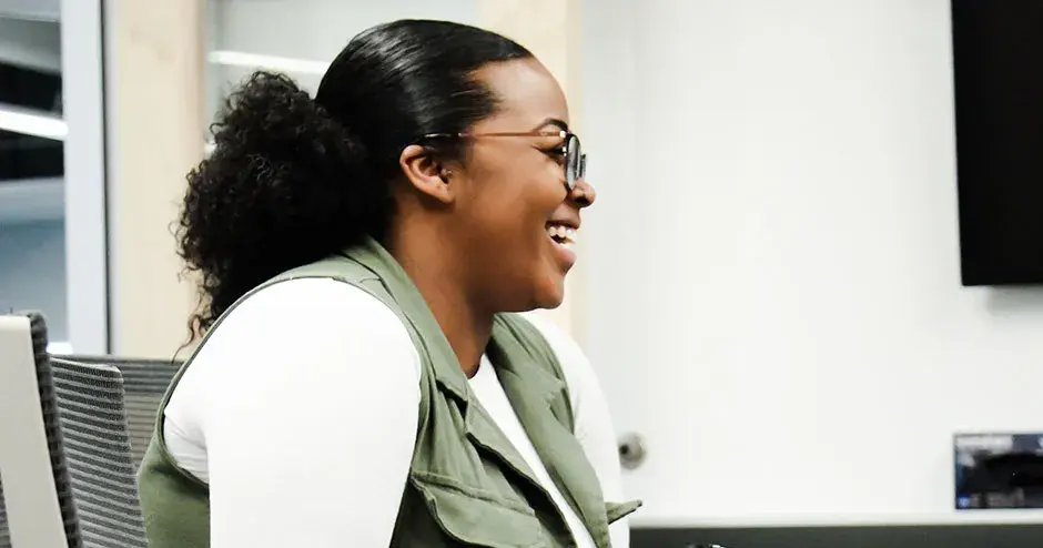 面带微笑坐在办公桌旁的同事