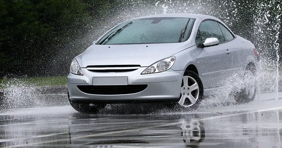 一辆汽车从水坑中驶过并溅起巨大水花