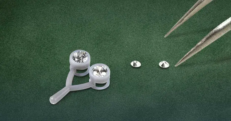 放置在绿色天鹅绒背景上的 figure 4 jewel master gry 珠宝吊坠和宝石