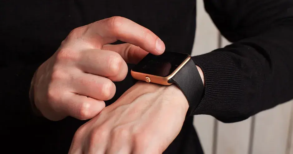 一位男士戴着手表，并指着手表的特征