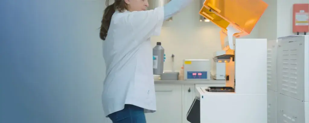 a person working in a dental lab using a 3D printer